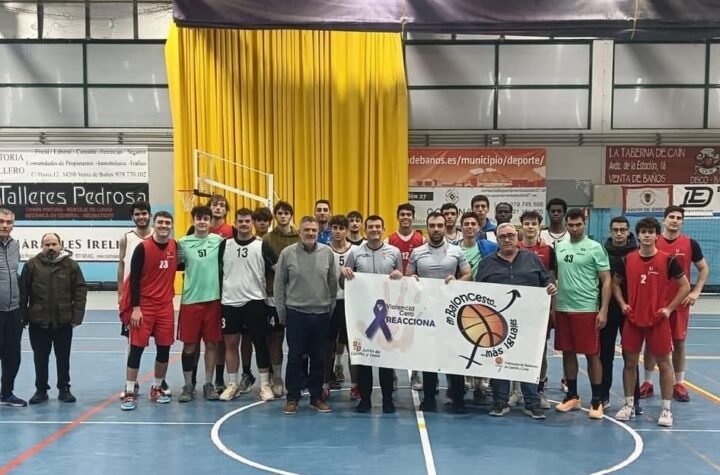 Group photo of male basketball players and coaches in an indoor court, holding a banner about anti-violence and basketball inclusion.A0