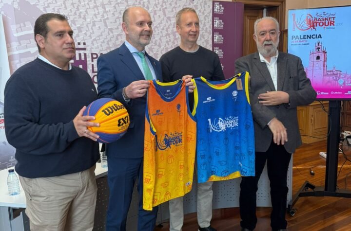 Four men posing with orange and blue basketball jerseys at a press event, holding the jerseys up for display in front of a banner and screen.