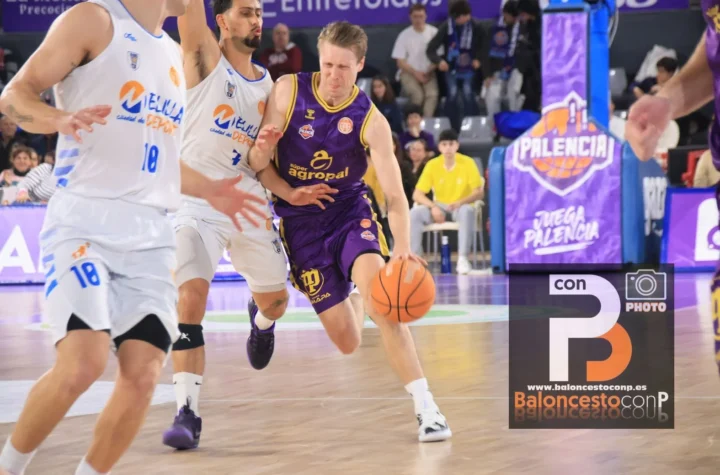 Basketball player in a purple uniform dribbles past white-uniform defenders during a fast break on a polished court with spectators in the background.