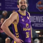 Basketball player in purple and yellow jersey #31 standing with hands on hips during a game of basketball.