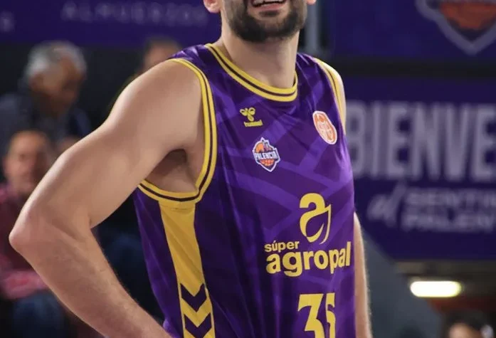 Basketball player in purple and yellow jersey #31 standing with hands on hips during a game of basketball.