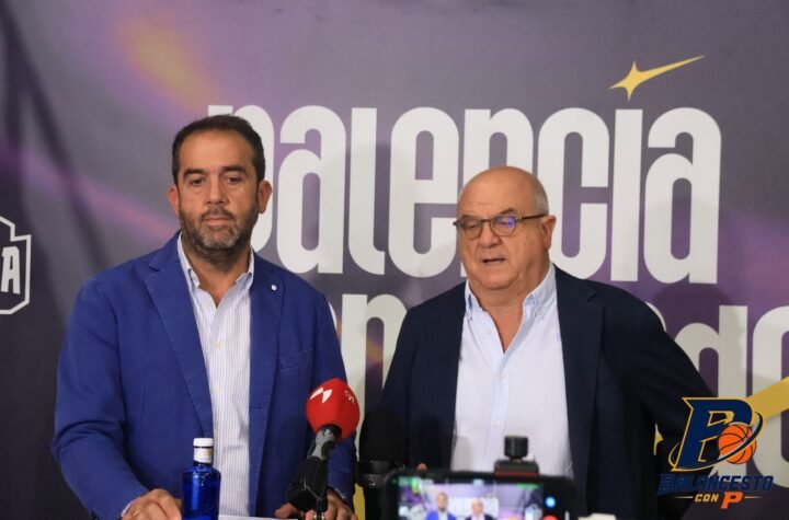 Two men in suits stand at a press conference with microphones; backdrop reads 'baloncesto' in large letters.